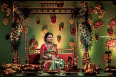 a woman sitting on top of a red couch in front of a table filled with food