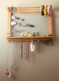 a wooden rack with jewelry hanging from it's sides