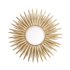 a gold sunburst shaped mirror on a white wall with an empty space in the middle