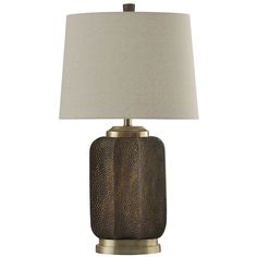 a table lamp with a white shade on it and a gold finish metal frame base