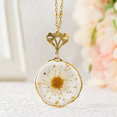 "Handmade real birth flower necklace featuring a dried pressed Daisy flower pendant. The birth flower is adorned with Queen Anne's lace and gold flakes. The beautiful dried flower pendant is embedded in a UV resin 32mm (1.26 inch) round irregular setting and is available in a gold or silver finish. The high quality stainless steel beaded chain is enhanced by a Victorian style floral bail. You can choose your chain length between 18\", 20\", 24\", 30\" inches. Your jewelry will arrive in a lovely Gold Nature-inspired Flower Necklace For Gift, Nature-inspired Gold Flower Necklace For Gift, Nature-inspired Gold Flower Pendant Necklace, Mother's Day Flower Necklace With Pressed Flowers, Flower Charm Necklace For Keepsake, Keepsake Flower Necklace With Flower Charm, Gold Botanical Necklace With Flower Charm, Delicate Pressed Flower Necklace For Mother's Day, Birth Flower Necklace Keepsake