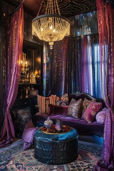 a purple couch sitting under a chandelier in a living room next to a window