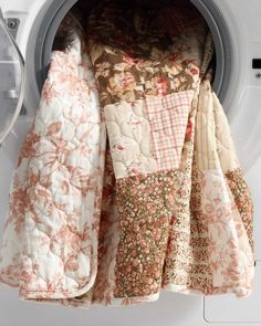 the inside of a washing machine filled with lots of different types of cloths and blankets