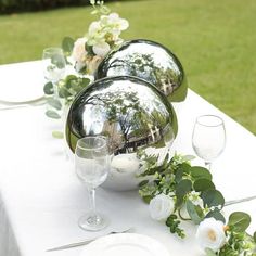 the table is set with plates, silverware and vases on top of it