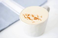 a close up of a white cup with orange sprinkles on it