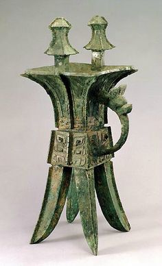 an old bronze vase with three candles on it