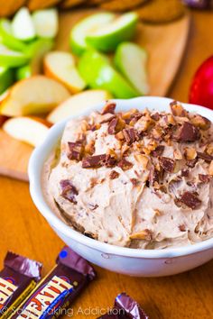 a bowl filled with ice cream next to sliced apples