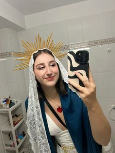 a woman taking a selfie in the bathroom wearing a nun outfit and holding a cell phone