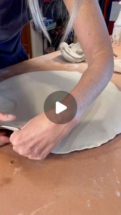 a woman is making clay with her hands