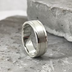 a silver ring sitting on top of a rock