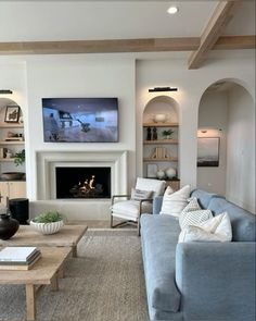 a living room filled with furniture and a fire place in front of a flat screen tv