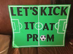 a green sign that says let's kick it at prom with a soccer field