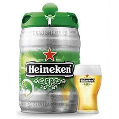 heineken beer in a glass next to a canister with a green lid