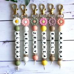 several key chains with flowers on them and words written in white letters that spell out the word