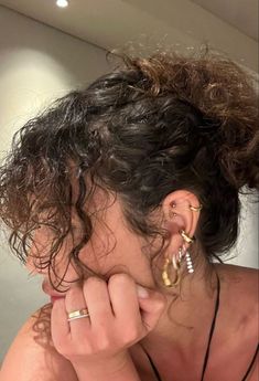 a woman with curly hair wearing ear rings