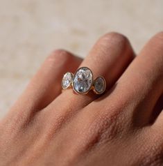 a woman's hand with three diamond rings on it