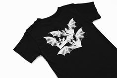 Inverted Vampire bat design t shirt  Vintage Halloween T Shirt Halloween Graphic Tee Spooky Season Shirt Halloween Aesthetic Tee Gothic Halloween Shirt Halloween Ghost Shirt Halloween Party TShirt Cute Halloween Designs Retro Halloween Apparel Funny Halloween Costume Shirt Witchy Vibes TShirt Halloween 2024 TShirt A classic unisex t-shirt that works well with any outfit. Made of a heavier cotton with a double-stitched neckline and sleeves. *Rolled-forward shoulders for a better fit *Stylish fitt White Gothic T-shirt For Streetwear, Edgy Halloween Fan Merchandise T-shirt, Edgy Halloween Graphic Tops, Gothic Black Shirt For Halloween, Edgy Halloween T-shirt With Sublimation Print, Spooky Black T-shirt With Screen Print, Edgy T-shirt With Sublimation Print For Halloween, Black Halloween Graphic T-shirt, Spooky Black Short Sleeve Shirt