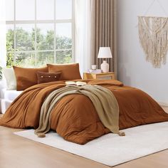 a bed with brown sheets and pillows in a room next to a white rug on the floor