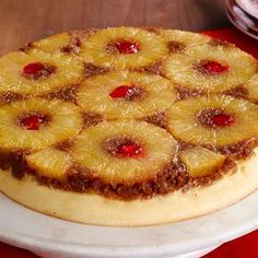 a pineapple upside down cake sitting on top of a white plate next to a red napkin