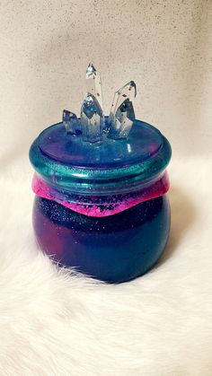 a blue and purple container sitting on top of a white fur covered floor