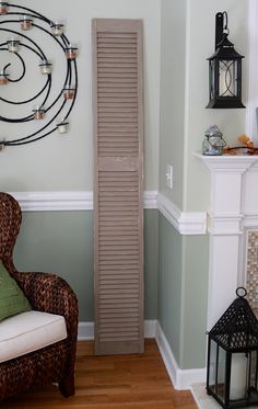 a room with a chair and a tall wooden ruler on the wall next to a fireplace