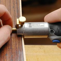 a person using a drill to attach a piece of wood with a screwdriver