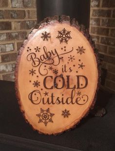 a wooden sign that says baby it's cold outside with snowflakes on it