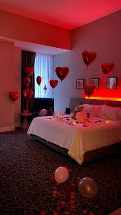 a bedroom decorated for valentine's day with heart balloons