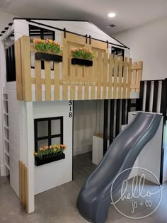 there is a loft bed with a slide and flower boxes on the bottom level,