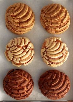 four cookies are arranged on a baking sheet and ready to be baked in the oven