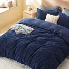 a bed with blue comforter and pillows in a bedroom