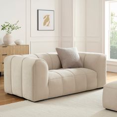 a living room scene with focus on the couch and chair in the foreground while the rug is on the floor