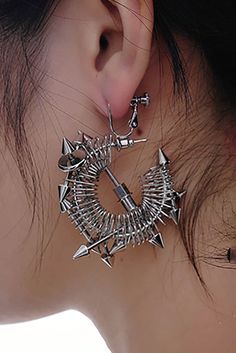 Embrace the perfect fusion of futuristic technology and punk aesthetics with our Temporal Shuttle Earrings. These earrings feature an open circular design, with sections wrapped in spring-like metal, evoking the concept of time travel. Adorned with multiple sharp metal cone accents, they add an edgy and dynamic touch. The central part showcases arrow-like metal elements, enhancing the geometric and innovative design. Crafted from premium materials, these earrings ensure durability and a luxuriou Edgy Metal Plug Earrings, Edgy Metal Hoop Earrings, Metal Punk Plug Earrings For Party, Silver Punk Plug Earrings For Parties, Edgy Metal Pierced Plug Earrings, Punk Metal Plug Earrings For Party, Punk Style Metal Plug Earrings For Parties, Modern Internally Threaded Metal Plug Earrings, Punk Metal Hoop Earrings