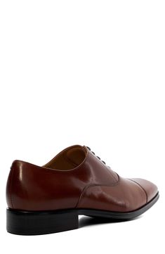 Tonal stitching subtly highlights the cap toe of a classic oxford fashioned from smooth, burnished leather. Lace-up style Leather upper/textile lining/synthetic sole Imported Cap Toe Oxfords For Derby, Fitted Cap Toe Oxfords For Derby, Fitted Oxford Derby Shoes With Almond Toe, Fitted Oxfords With Leather Sole, Fitted Almond Toe Derby Shoes In Oxford, Fitted Almond Toe Derby Oxford Shoes, Fitted Almond Toe Derby Shoes, Fitted Oxford Leather Shoes With Goodyear Welt, Fitted Plain Toe Oxford With Leather Sole