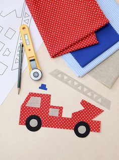 sewing supplies are laid out on the table to make a paper firetruck craft