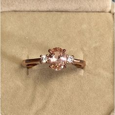 an engagement ring with three stones in it on top of a cloth covered tablecloth