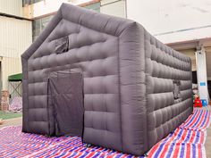 an inflatable house is on top of a red, white and blue blanket