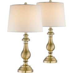 pair of gold metal table lamps with white linen shades on each lamp and one light off