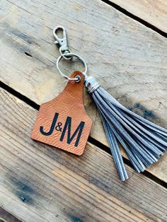 "Personalized cow tag keychains with fringe accessory: customize these clip on animal tags with your Ranch Brand, Business Logo, Initials, Name, etc. These make the perfect western keychain for the Cowgirl or Cowboy in your life! Also great for diaper bag name tag, kids backpack accessory, western luggage tag, etc! BULK ORDER PRICING AVAILABLE- message us for details!  Single Sided option will only have etched name or logo on one side. Other side will be blank like pictured. Double sided will be twice as thick and have tan leatherette with logo or name etched on both sides.  Size:  Cow Tag 2.5\" x 1.75\"  Fringe accessory 3.5\" long Material: Faux leather tag with laser etching, suede fringe accessory, metal lobster claw clasp" Customizable Rectangular Keychain For Everyday Use, Personalized Rectangular Keychains For Everyday Use, Personalized Rectangular Keychain For Everyday, Western Luggage, Cow Tag Keychain, Western Keychain, Western Names, Fringe Accessories, Cow Tag