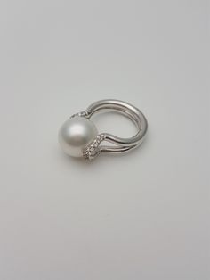 This elegant and timeless pearl and diamonds white gold ring are a must-have in a woman's wardrobe. It goes perfectly with almost anything Great gift for a young lady Beautiful high quality real South Sea and a real diamonds The pearl is a white rose in color, smooth and shiny very clean with high luster The diamond is pave set and is of H/VS quality Hand made * genuine South sea cultured pearl * 13.7 mm in diameter * round in shape * high luster * grade AAA * 18K gold * 0.30 carats total weight Modern White Pearl Ring For Wedding, South Sea Pearl Ring, Real Diamond Rings, Diamonds Ring, Sea Pearl, South Seas, South Sea Pearls, Sea Pearls, Pearl Ring