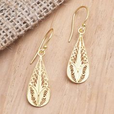 Capture the warm glow of gold with the help of these elegant dangle earrings designed by Bali's Yuniati. The artisan crafts the drop-shaped earrings from 18 gold-plated sterling silver using fine wires to create ornamental filigree work that adds a decorative touch to the already lovely earrings. Artisan Yellow Gold Teardrop Jewelry, Gold Plated Filigree Teardrop Jewelry, Artisan Gold Teardrop Pendant Jewelry, Teardrop-shaped Gold Plated Filigree Jewelry, Artisan Gold Long Drop Earrings, Gold Long Drop Artisan Earrings, Gold Teardrop Pendant Earrings For Gift, Artisan Long Drop Gold Jewelry, Gold Brass Long Drop Teardrop Earrings