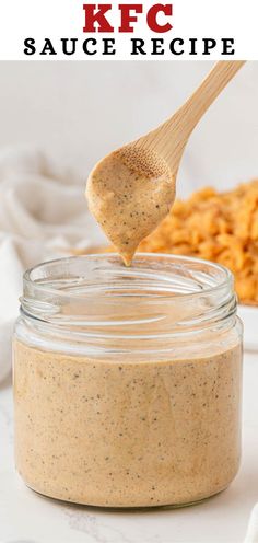 a spoon full of peanut butter on top of a jar