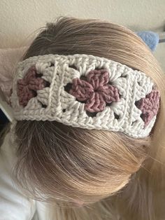 a close up of a person wearing a headband with flowers on the front and side