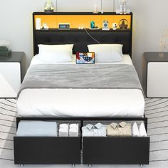 a bed with two drawers underneath it in a white and black bedroom, next to a yellow book shelf