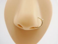 the nose ring is on top of a fake dummy's head and has a diamond in it