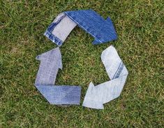 several pieces of denim sitting on top of the grass with one piece cut out to look like an arrow