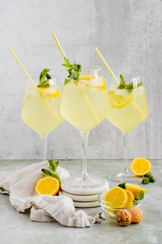 three glasses filled with lemonade and garnished with mint