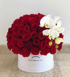 a white box with red roses and orchids