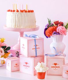 a table topped with boxes filled with cake and flowers