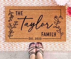 a person standing in front of a door mat that says the taylor family